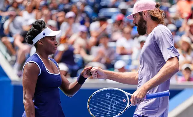 Venus Williams fist bumps her partner Reilly Opelka during the mixed doubles competition of the U.S. Open tennis tournament in New York, Tuesday, Aug. 19, 2025. (AP Photo/Yuki Iwamura)