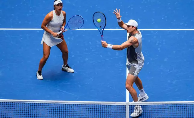 Jack Draper, right, of United States, plays a shot as partner Jessica Pegula, of United States, covers during their mixed doubles match at the U.S. Open tennis championships, Tuesday, Aug. 19, 2025, in New York. (AP Photo/Yuki Iwamura)
