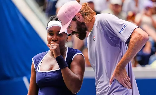 Venus Williams talks with her partner Reilly Opelka during the mixed doubles competition of the U.S. Open tennis tournament in New York, Tuesday, Aug. 19, 2025. (AP Photo/Yuki Iwamura)