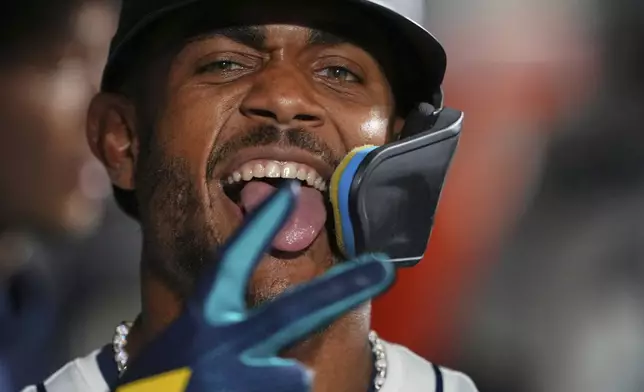 Seattle Mariners' Julio Rodriguez poses in the dugout after scoring on an RBI sacrifice fly from teammate Eugenio Suarez against the Chicago White Sox during the seventh inning of a baseball game Wednesday, Aug. 6, 2025, in Seattle. (AP Photo/Lindsey Wasson)
