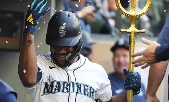 Seattle Mariners' Julio Rodriguez celebrates in the dugout after hitting a three-run home run against the Chicago White Sox during the second inning of a baseball game Wednesday, Aug. 6, 2025, in Seattle. (AP Photo/Lindsey Wasson)