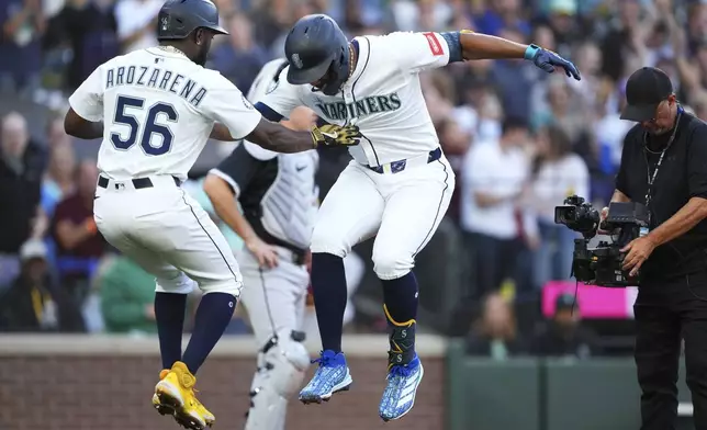 Seattle Mariners' Randy Arozarena (56) celebrates with Julio Rodriguez, right, after Rodriguez hit a three-run home run against the Chicago White Sox during the second inning of a baseball game Wednesday, Aug. 6, 2025, in Seattle. (AP Photo/Lindsey Wasson)