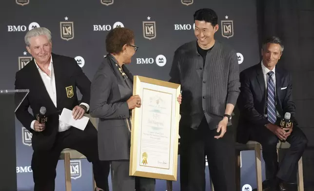 Son Heung-min, of South Korea, center right, stands next to Los Angeles Mayor Karen Bass as he is introduced as a new member of Los Angeles FC during a press conference for the MLS soccer team Wednesday, Aug. 6, 2025, in Los Angeles. (AP Photo/Damian Dovarganes)