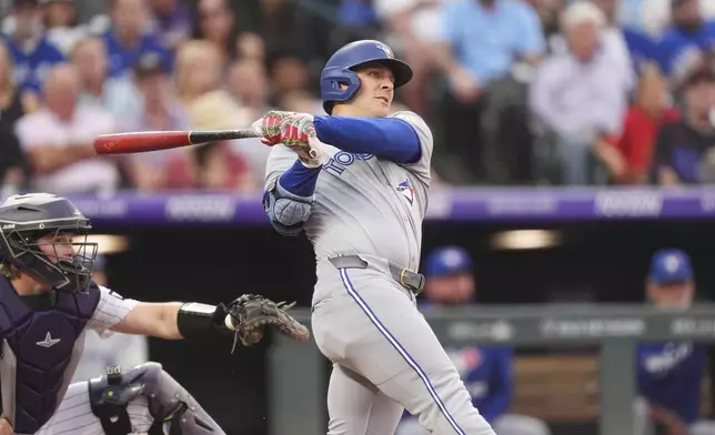 Toronto Blue Jays' Daulton Varsho hits a two-run home run off Colorado Rockies starting pitcher Anthony Molina in the fourth inning of a baseball game Tuesday, Aug. 5, 2025, in Denver. (AP Photo/David Zalubowski)