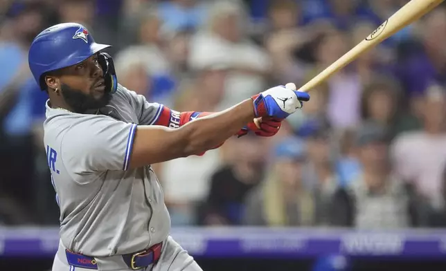 Toronto Blue Jays' Vladimir Guerrero Jr. follows the flight of his RBI double off Colorado Rockies relief pitcher Jaden Hill in the ninth inning of a baseball game Tuesday, Aug. 5, 2025, in Denver. (AP Photo/David Zalubowski)