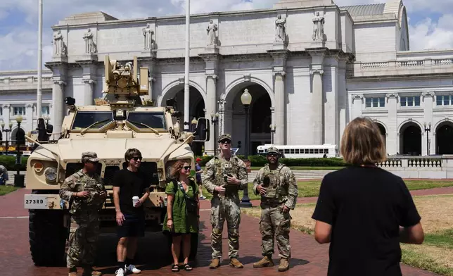 District of Columbia National Guard soldiers pose for photos with people outside Union Station, Saturday, Aug. 16, 2025, in Washington. (AP Photo/Julia Demaree Nikhinson)