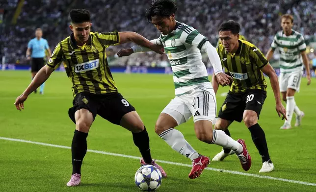 Kairat's Dastan Satpayev, left, and and Celtic's Reo Hatate battle for the ball during the UEFA Champions League playoff first leg soccer match at Celtic Park, Wednesday, Aug. 20, 2025, in Glasgow, Scotland. (Andrew Milligan/PA via AP)