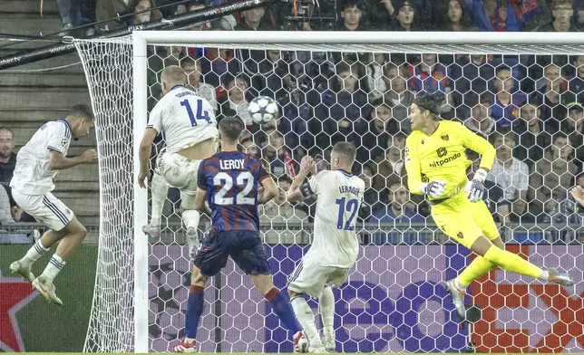 Copenhagen's Gabriel Pereira, left, scores a goal past Basel's goalkeeper Marwin Hitz, right, during the UEFA Champions League playoff first leg match between Switzerland's FC Basel 1893 and Denmark's F.C. Copenhagen at the St. Jakob-Park stadium in Basel, Switzerland, on Wednesday, Aug. 20, 2025. (Georgios Kefalas/Keystone via AP)