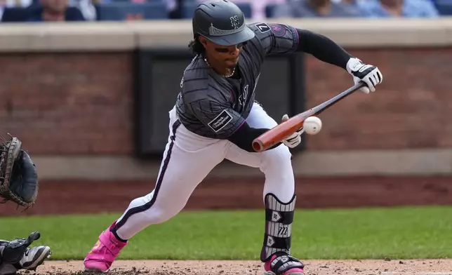 New York Mets' Francisco Lindor hits a bunt single during the fourth inning of a baseball game against the San Francisco Giants, Saturday, Aug. 2, 2025, in New York. (AP Photo/Yuki Iwamura)
