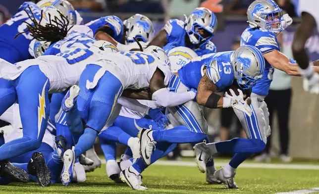 Detroit Lions running back Craig Reynolds (13) runs the ball in for a touchdown against the Los Angeles Chargers in the first half of the Pro Football Hall of Fame NFL preseason game Thursday, July 31, 2025, in Canton, Ohio. (AP Photo/David Dermer)
