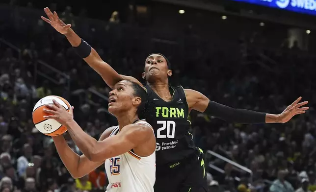 Seattle Storm guard Brittney Sykes (20) fouls Phoenix Mercury forward Alyssa Thomas, left, near the basket during the first half of a WNBA basketball game Sunday, Aug. 17, 2025, in Seattle. (AP Photo/Lindsey Wasson)
