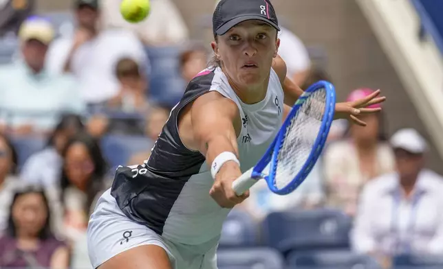 Iga Swiatek, of Poland, returns a shot to Suzan Lamens, of the Netherlands, during the second round of the U.S. Open tennis championships, Thursday, Aug. 28, 2025, in New York. (AP Photo/Seth Wenig)