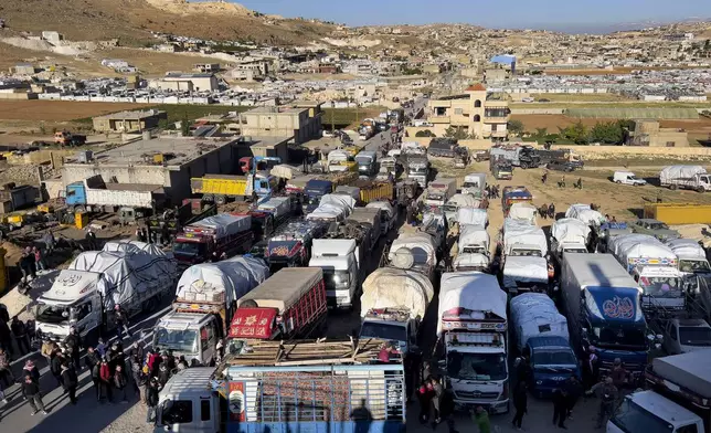 FILE - Syrian refugees gather near trucks with their belongings, as they prepare to go back home to Syria as a part of a voluntary return, in the eastern Lebanese border town of Arsal, Tuesday, May 14, 2024. (AP Photo/Hussein Malla, File)
