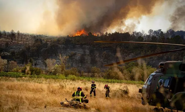 This photo provided by the Securite Civile on Friday, Aug.8, 2025 shows firefighters next to a wildfire Thursday, Aug. 7, 2025 near Jonquieres, southern France. (Securite Civile via AP)