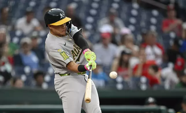 Athletics' Gio Urshela hits a double against Washington Nationals pitcher MacKenzie Gore during the first inning of a baseball game in Washington, Tuesday, Aug. 5, 2025. (AP Photo/Terrance Williams)