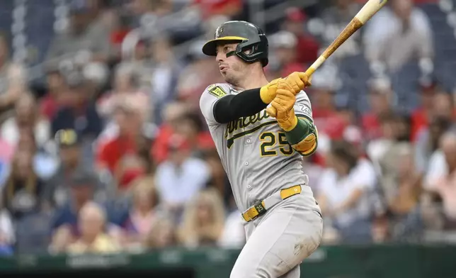 Athletics' Brent Rooker (25) follows through on his swing after hitting a single against Washington Nationals pitcher MacKenzie Gore during the second inning of a baseball game in Washington, Tuesday, Aug. 5, 2025. (AP Photo/Terrance Williams)