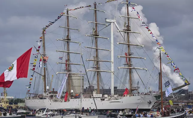 A tall ship from Peru joins hundreds of tall ships sailing into the Dutch capital's harbor for the 10th edition of SAIL, in Amsterdam, Netherlands, Wednesday, Aug. 20, 2025. (AP Photo/Peter Dejong)