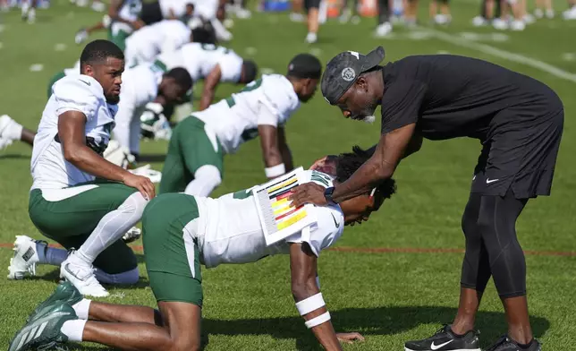 New York Jets' head coach Aaron Glenn, right, greets Garrett Wilson during a joint NFL football practice with the New York Giants in East Rutherford, N.J., Wednesday, Aug. 13, 2025. (AP Photo/Seth Wenig)