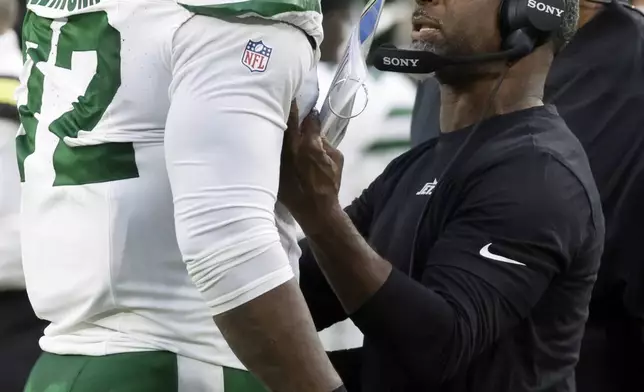 New York Jets head coach Aaron Glenn talks to Micheal Clemons during the first half of a preseason NFL football game against the Green Bay Packers Saturday, Aug. 9, 2025, in Green Bay, Wis. (AP Photo/Matt Ludtke)