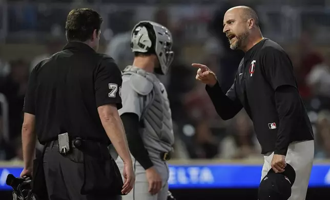 Minnesota Twins manager Rocco Baldelli, right, reacts toward home umpire John Bacon, left, after being ejected during the 11th inning of a baseball game against the Detroit Tigers, Thursday, Aug. 14, 2025, in Minneapolis. (AP Photo/Abbie Parr)