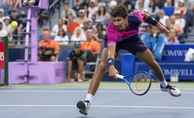 Alexei Popyrin, of Australia, chases down a shot from Holger Rune, of Denmark, during their men's match at the National Bank Open tennis tournament in Toronto, Saturday, Aug. 2, 2025. (Frank Gunn/The Canadian Press via AP)