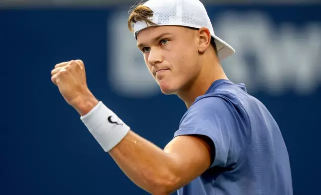 Holger Rune of Denmark pumps his fist after holding serve against Alexei Popyrin of Australia during their match at the National Bank Open in Toronto, Saturday, Aug. 2, 2025. (Frank Gunn/The Canadian Press via AP)