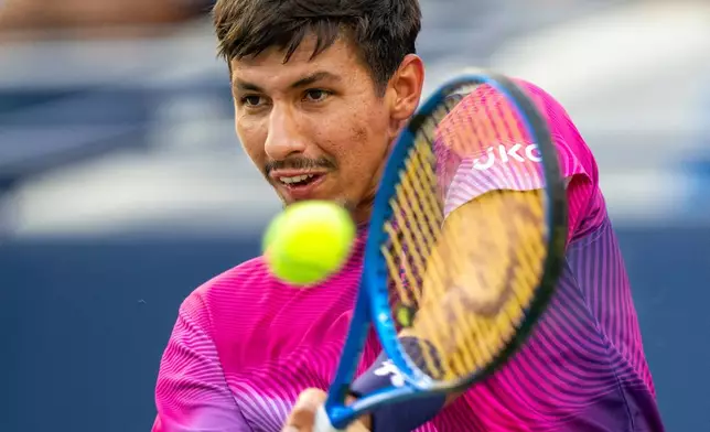 Alexei Popyrin, of Australia, hits a backhand return to Holger Rune, of Denmark, during their men's match at the National Bank Open tennis tournament in Toronto, Saturday, Aug. 2, 2025. (Frank Gunn/The Canadian Press via AP)