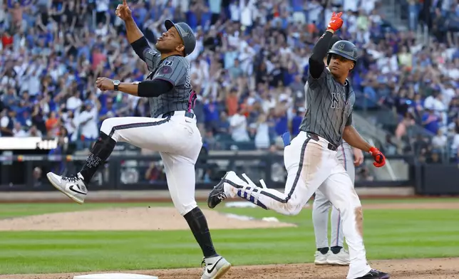 New York Mets first base coach Antoan Richardson, left, reacts after a home run by Juan Soto, right, during the sixth inning of a baseball game against the Miami Marlins, Saturday, Aug. 30, 2025, in New York. (AP Photo/Noah K. Murray)