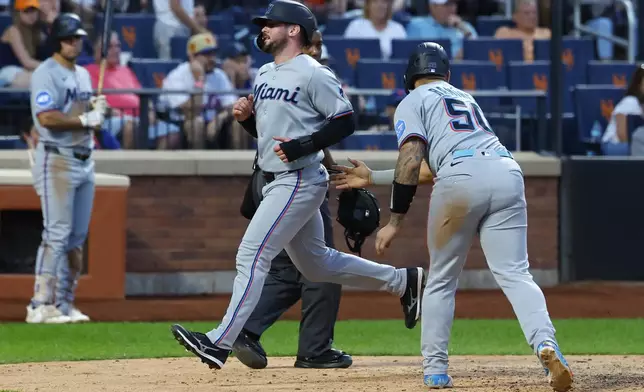 Miami Marlins' Liam Hicks scores after Agustín Ramírez (50) during the ninth inning of a baseball game against the New York Mets, Saturday, Aug. 30, 2025, in New York. (AP Photo/Noah K. Murray)