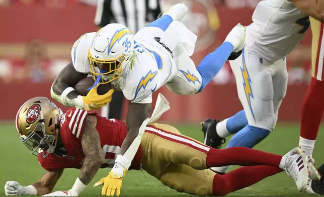 Los Angeles Chargers running back Raheim Sanders (35) jumps over San Francisco 49ers cornerback Chase Lucas during the second half of an NFL preseason football game in Santa Clara, Calif., Saturday, Aug. 23, 2025. (AP Photo/Eakin Howard)