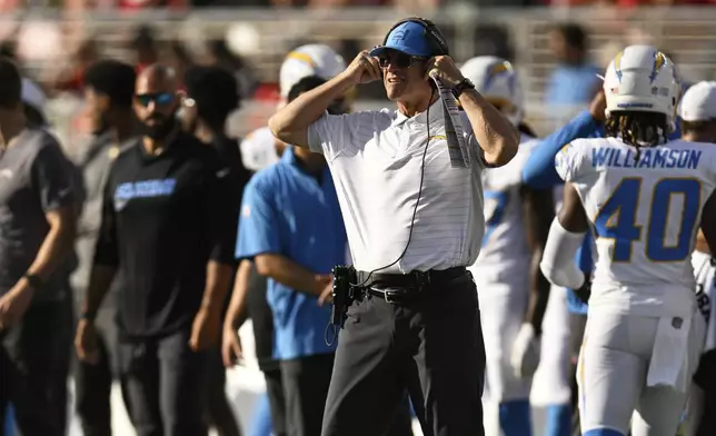 Los Angeles Chargers head coach Jim Harbaugh, middle, watches from the sideline during the first half of an NFL preseason football game against the San Francisco 49ers in Santa Clara, Calif., Saturday, Aug. 23, 2025. (AP Photo/Eakin Howard)
