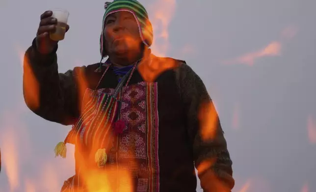Spiritual leader Eusebio Huanca burns offerings observing the month of Pachamama, or Mother Earth, performing an ancient tradition to ask for a good harvest, on La Cumbre, a mountain considered sacred on the outskirts of La Paz, Bolivia, Friday, Aug. 1, 2025. (AP Photo/Juan Karita)