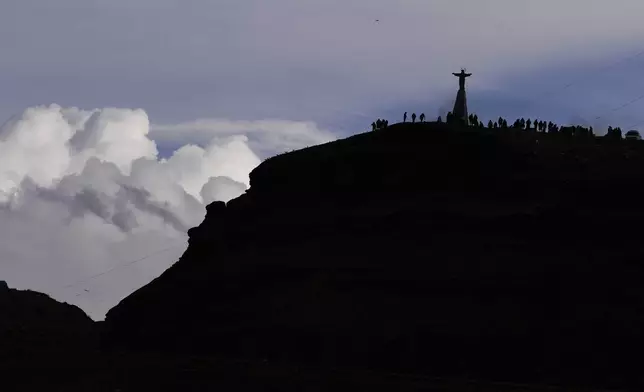 People gather on La Cumbre, a mountain considered sacred to burn offerings observing the month of Pachamama, or Mother Earth, performing an ancient tradition to ask for a good harvest, on the outskirts of La Paz, Bolivia, Friday, Aug. 1, 2025. (AP Photo/Juan Karita)