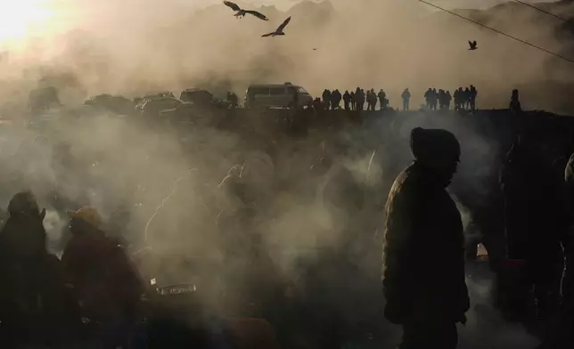 People burn offerings observing the month of Pachamama, or Mother Earth, performing an ancient tradition to ask for a good harvest, on La Cumbre, a mountain considered sacred on the outskirts of La Paz, Bolivia, Friday, Aug. 1, 2025. (AP Photo/Juan Karita)