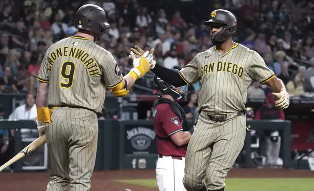 San Diego Padres' Xander Bogaerts celebrates with Jake Cronenworth (9) after hitting a solo home run against the Arizona Diamondbacks in the seventh inning during a baseball game, Wednesday, Aug 6, 2025, in Phoenix. (AP Photo/Rick Scuteri)