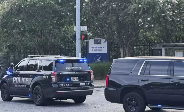 The Centers for Disease Control and Prevention headquarters sign is seen behind a police line in Atlanta on Friday, Aug. 8, 2025. (AP Photo/Jeff Amy)