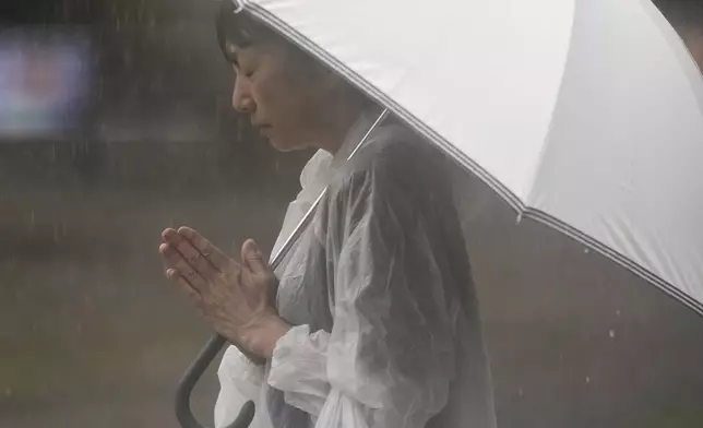 A person prays, ahead of a ceremony to mark the 80th anniversary of the WWII U.S. atomic bombing at Atomic Bomb Hypocenter Park in Nagasaki, western Japan Saturday, Aug. 9, 2025. (AP Photo/Eugene Hoshiko)