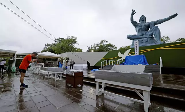 A visitor prays in front of the Peace Statue at the Peace Park in Nagasaki, marking the 80th anniversary of the U.S. atomic bombing of the southwestern Japanese city, Saturday, Aug. 9, 2025. (Kyodo News via AP)
