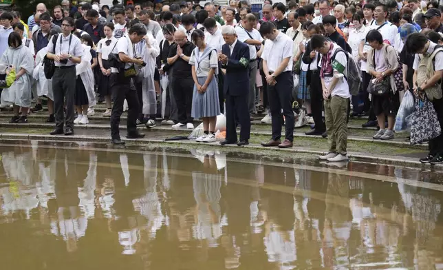 People observe a minute of silence at the Atomic Bomb Hypocenter Park, during a ceremony to commemorate the 80th anniversary of the day an atomic bomb was dropped on Japanese southwestern city, in Nagasaki, Japan Saturday, Aug. 9, 2025.(AP Photo/Eugene Hoshiko)