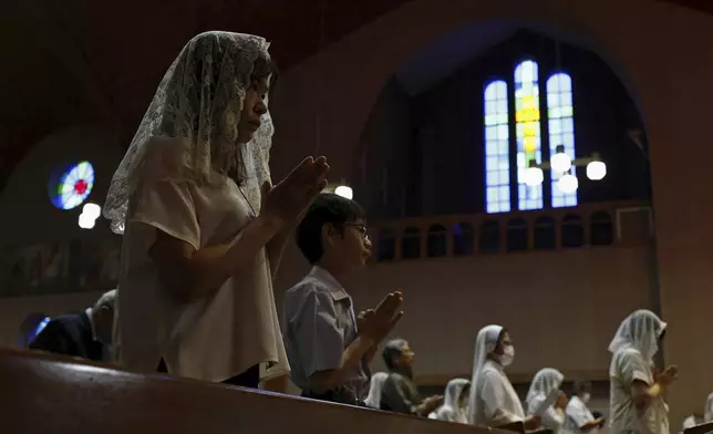 Faithful people offer prayers at the Urakami Cathedral in Nagasaki Saturday, Aug. 9, 2025, marking the 80th anniversary of the U.S. atomic bombing of the southwestern Japanese city. (Kyodo News via AP)