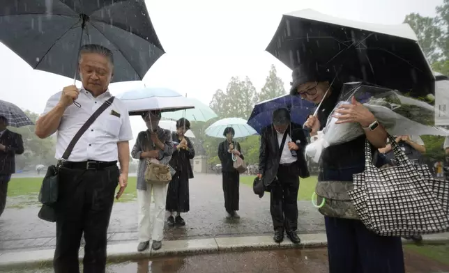 People gather, ahead of a public ceremony to commemorate the 80th anniversary of the day an atomic bomb was dropped on Nagasaki, at the Atomic Bomb Hypocenter Park in Nagasaki, Japan Saturday, Aug. 9, 2025. (AP Photo/Eugene Hoshiko)