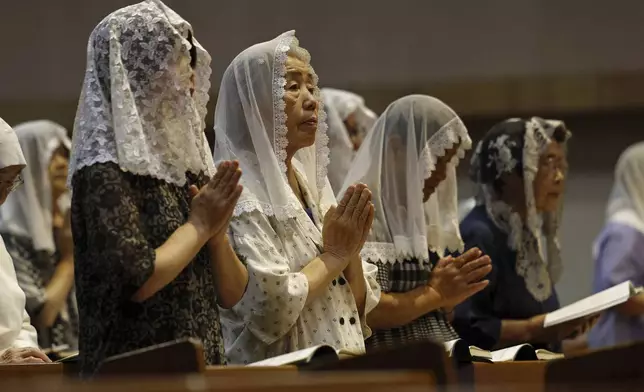 Faithful people offer prayers at the Urakami Cathedral in Nagasaki Saturday, Aug. 9, 2025, marking the 80th anniversary of the U.S. atomic bombing of the southwestern Japanese city. (Kyodo News via AP)