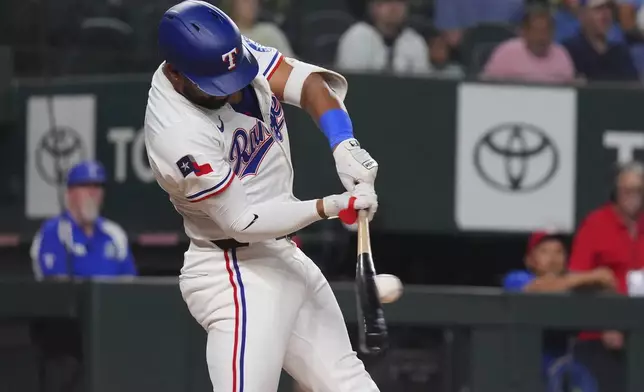 Texas Rangers' Ezequiel Duran hits a single that scored teammates Josh Jung and Josh Smith during the second inning of a baseball game against the New York Yankees, Monday, Aug. 4, 2025, in Arlington, Texas. (AP Photo/LM Otero)