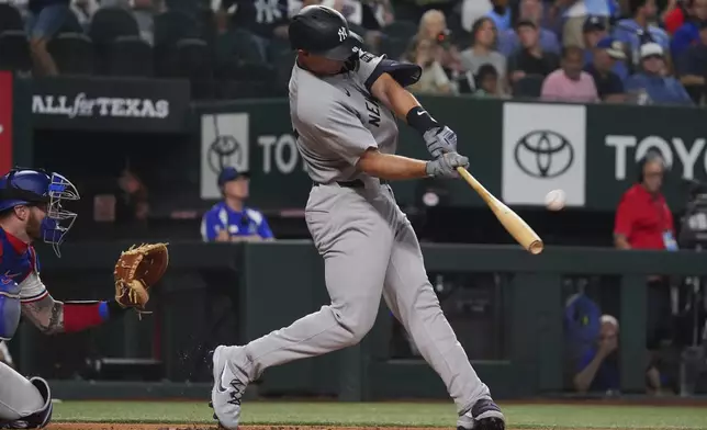 New York Yankees' Paul Goldschmidt, right, hits a home run in front of Texas Rangers catcher Jonah Heim, left, during the first inning of a baseball game, Monday, Aug. 4, 2025, in Arlington, Texas. (AP Photo/LM Otero)