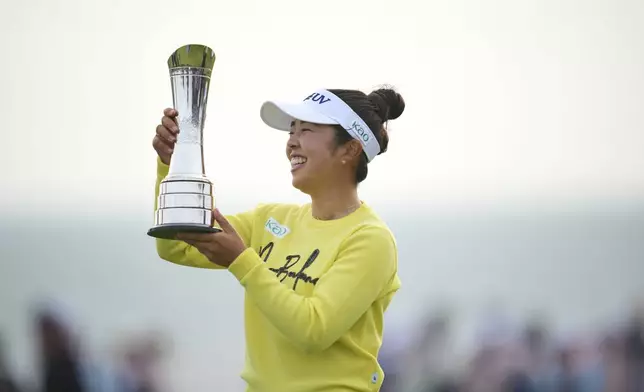 Miyu Yamashita of Japan holds up her trophy after winning the Women's British Open golf championship, at Royal Porthcawl Golf Club in Porthcawl, Wales, Sunday, Aug. 3, 2025. (AP Photo/Kin Cheung)