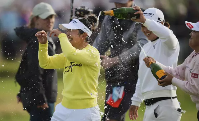 Miyu Yamashita, left, of Japan is sprayed with champagne as she celebrates after winning the Women's British Open golf championship, at Royal Porthcawl Golf Club in Porthcawl, Wales, Sunday, Aug. 3, 2025. (AP Photo/Kin Cheung)