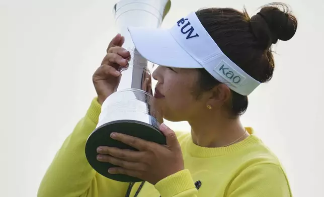 Miyu Yamashita of Japan kisses her trophy after winning the Women's British Open golf championship, at Royal Porthcawl Golf Club in Porthcawl, Wales, Sunday, Aug. 3, 2025. (AP Photo/Kin Cheung)
