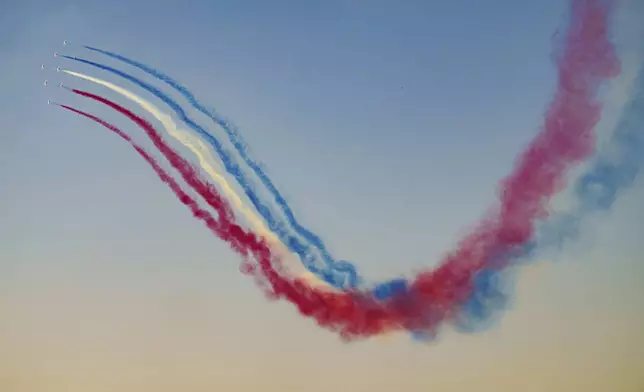 Pilots of the Patrouille de France (PAF), the precision aerobatics unit of the French Air and Space Force, perform above the runway of the Aurel Vlaicu airport, on the first day of the Bucharest International Air Show, BIAS 2025 in Bucharest, Romania, Saturday, Aug. 30, 2025. (AP Photo/Andreea Alexandru)