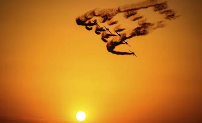 Pilots of the Hawks of Romania aerobatic team perform above the runway of the Aurel Vlaicu airport, on the first day of the Bucharest International Air Show, BIAS 2025 in Bucharest, Romania, Saturday, Aug. 30, 2025. (AP Photo/Andreea Alexandru)