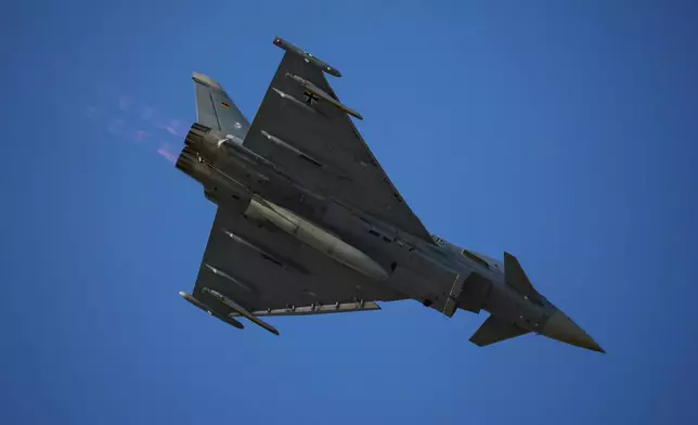 An Eurofighter Typhoon German Air Force fighter jet flies above the runway of the Aurel Vlaicu airport, on the first day of the Bucharest International Air Show, BIAS, in Bucharest, Romania, Saturday, Aug. 30, 2025. (AP Photo/Andreea Alexandru)